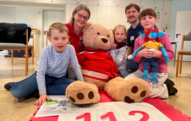 Nina Siegle und JRK-Gruppenleiter Philip Falliano mit den Kindern, sowie mit JRK-Bärin "Maja" und dem Außerirdischen „Umpsa“.