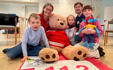 Nina Siegle und JRK-Gruppenleiter Philip Falliano mit den Kindern, sowie mit JRK-Bärin "Maja" und dem Außerirdischen „Umpsa“.