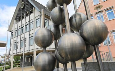 Wären diese Kugeln am Brunnen vor dem Rathaus prall gefüllte Geldsäcke, wäre der Gemeinde (etwas) geholfen. (Archivbild)
