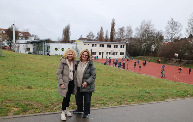 Rektorin Ulrike Dengler (links) und Konrektorin Alicia Grötsch - hinter ihnen sind die Hungerbergschule zu sehen, der Wiesenhang