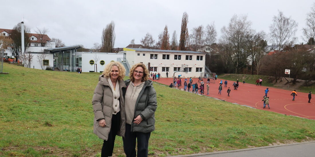 Rektorin Ulrike Dengler (links) und Konrektorin Alicia Grötsch - hinter ihnen sind die Hungerbergschule zu sehen, der Wiesenhang