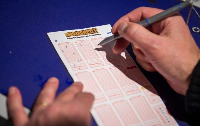 Mann kreuzt auf Lottoschein des Spiels «Eurojackpot» Zahlen an