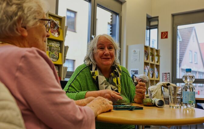 Wertvolle ehrenamtliche Hilfe: Monika Petersen (rechts) erklärt Gisela Luckert, wie ihr Handy-Wecker funktioniert.