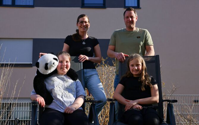 Emily mit ihrem Kuschelpanda Lilly, ihrer Zwillingssschwester Leni, ihrer Mutter Sarah und ihrem Vater