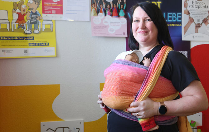 Als Trageberaterin weiß Tamara Krüger, wie das Baby - in diesem Fall eine Puppe - richtig in einem Tragetuch eingebunden ist.