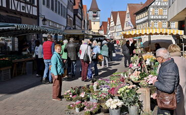 Kunden unterhalten sich und Marktbeschicker bieten ihre Ware auf dem Wochenmarkt in Winnenden an.