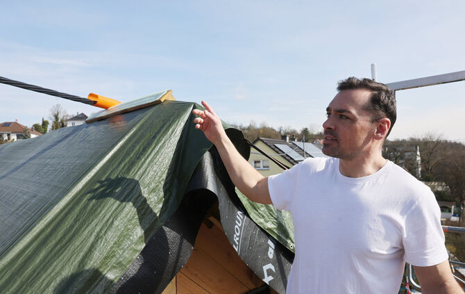 Sven Gamerdinger zeigt das Stromkabel, das auf seinem Dach aufliegt.