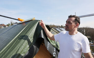 Sven Gamerdinger zeigt das Stromkabel, das auf seinem Dach aufliegt.