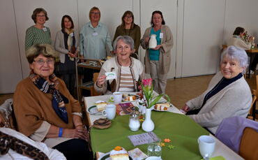 Das Organisationsteam (hinten) freut sich über die Besucher, die zum Angebot "Kaffee in Gemeinschaft" erscheinen.