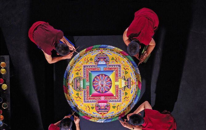 Mönche aus Ladakh legen im Linden-Museum Stuttgart ein Sandmandala. Die farbenfrohe Kreisform zeigt traditionelle buddhistische