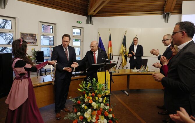 Das Winnender Mädle Lisa Keidel reicht Stadtrat Richard Fischer die Bürgermeister-Kette, der sie wiederum Hartmut Holzwarth umhä