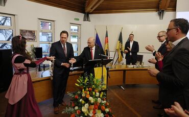 Das Winnender Mädle Lisa Keidel reicht Stadtrat Richard Fischer die Bürgermeister-Kette, der sie wiederum Hartmut Holzwarth umhä