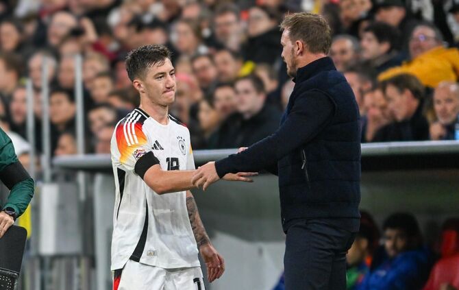 Angelo Stiller klatscht bei einer Auswechslung mit Bundestrainer Julian Nagelsmann ab.