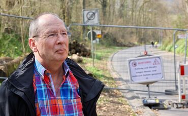 Jürgen Maser vor dem abgesperrten Unfallort auf der Klinglestalstraße. Im Hintergrund gefällte Bäume.