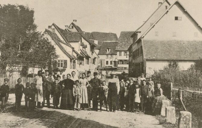 Gruppenaufnahme in der Waiblinger Straße, um 1910. Hinten rechts ist die Gaststätte zum Schwanen erkennbar.