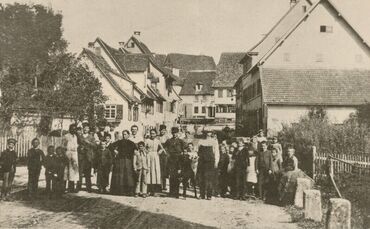 Gruppenaufnahme in der Waiblinger Straße, um 1910. Hinten rechts ist die Gaststätte zum Schwanen erkennbar.