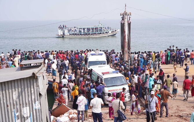 Rettungskräfte und zahlreiche Menschen versammeln sich an einer Unfallstelle, nachdem ein Bus in den Fluss Padma stürzte.