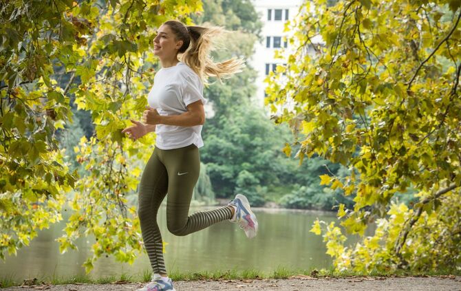 Junge Frau joggt durch einen Park