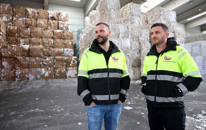 Manuel Schief (links) und Alexander Neckermann Schief. Im Hintergrund gelagert: Hunderte gepresste Papierballen.