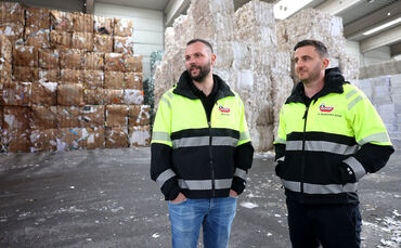 Manuel Schief (links) und Alexander Neckermann Schief. Im Hintergrund gelagert: Hunderte gepresste Papierballen.