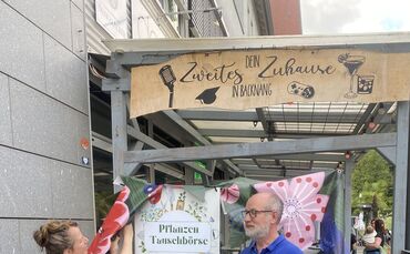 Claudia Fischer und Dirk Jerusalem am Tauschregal vor dem dasWohnzimmer.