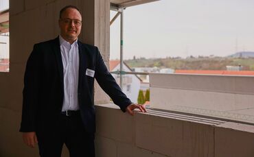 Björn Riker, Geschäftsführer der Riker Wohnbau + Immobilien GmbH, zeigt im obersten Geschoss des neuen Wohngebäudes die Aussicht