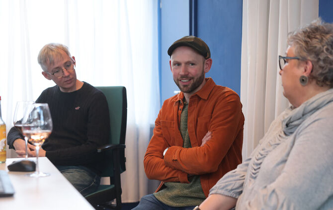 Der Strümpfelbacher Winzer Marcel Idler (Mitte) abends in der Pop-up-Redaktion am Bahnhof Beutelsbach.
