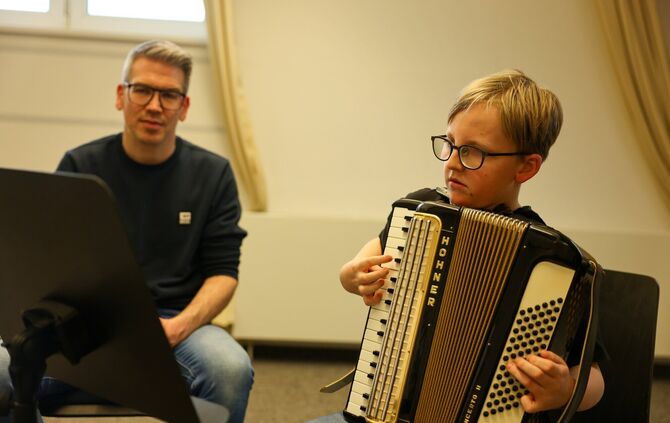 Jürgen Moll bringt Emil in der Jugendmusikschule das Akkordeonspielen bei.