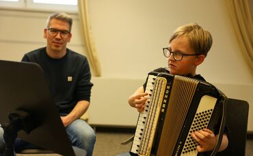 Jürgen Moll bringt Emil in der Jugendmusikschule das Akkordeonspielen bei.