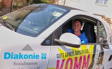 Isabel Löhr in dem Auto, mit dem sie für die Diakonie und Sozialstation Waiblingen im Einsatz ist.