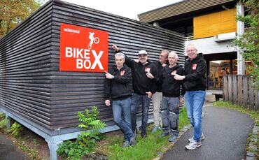 Das Team der BikeBox präsentiert sich vor der Fahrradwerkstatt auf dem Gelände der Diakonie Stetten.