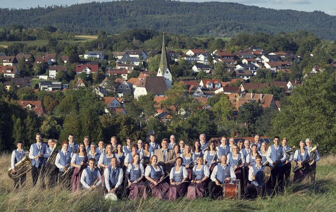 Das Aktivenorchester des Musikvereins Unterweissach vor der Kulisse von Weissach im Tal.