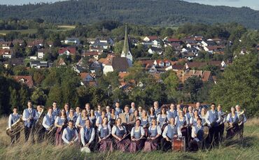 Das Aktivenorchester des Musikvereins Unterweissach vor der Kulisse von Weissach im Tal.