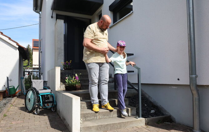 Luise bekommt beim Treppensteigen Unterstützung von ihrem Vater.