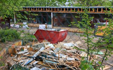 Blick durch den Maschendrahtzaun, der das alte Körnle-Kindergarten-Areal einfasst: Über die entsorgten Möbel regt sich eine Bürg