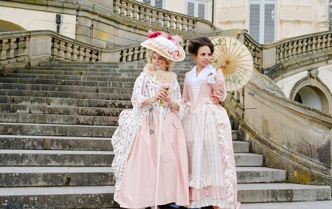 Zwei Frauen in barocken Kostümen auf der Freitreppe von Schloss Solitude beim Aktionstag „Palast Picknick".