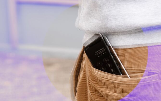 Ein Handy ragt aus einer Hosentasche
