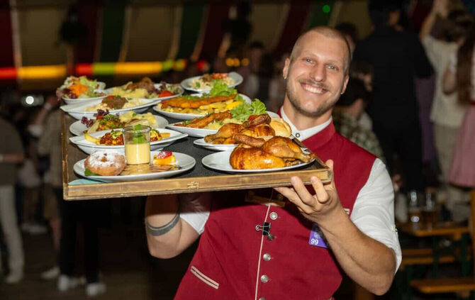 Tim Lehmann arbeitet als Bedienung im "Wasenwirt". Dort serviert er den feiernden Gästen unter anderem Bier und Göckele.