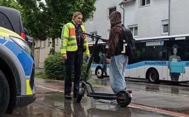 Eine Polizeibeamtin kontrolliert einen E-Scooter-Fahrer an der Paulinenstraße auf Höhe der Langen Gasse.