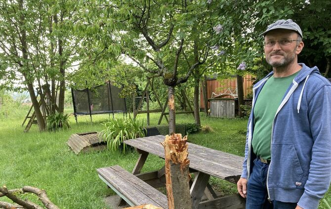 Adrian Dona vor den Resten der Zerstörung. Das meiste Holz hat er schon abgeräumt.