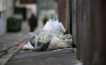 Müllsäcke und Abfall auf einem Gehweg
