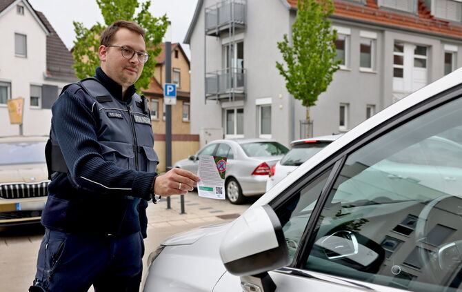 Markus Weiser vom Gemeindevollzugsdienst mit einem digitalen Knöllchen: Der QR-Code auf dem Blatt verbindet den Strafzettel mit