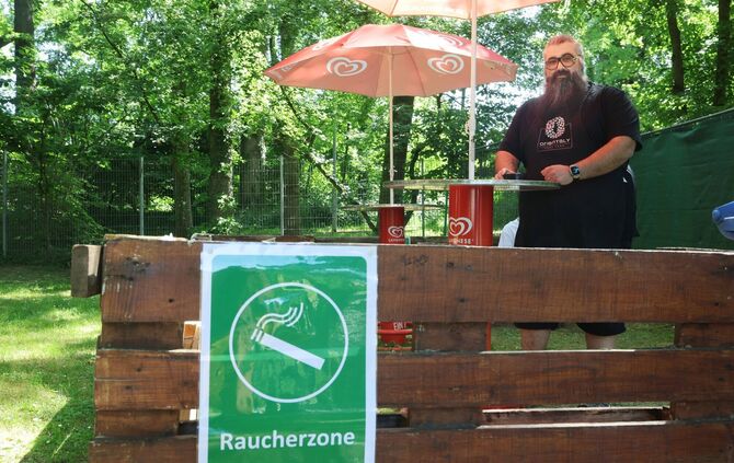 Imbiss-Pächter Salvatore Pirone zeigt die neue "Raucherzone" im Waldfreibad in Waiblingen-Bittenfeld. Außerhalb davon gilt: Rauc