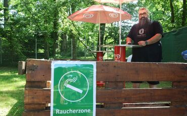 Imbiss-Pächter Salvatore Pirone zeigt die neue "Raucherzone" im Waldfreibad in Waiblingen-Bittenfeld. Außerhalb davon gilt: Rauc