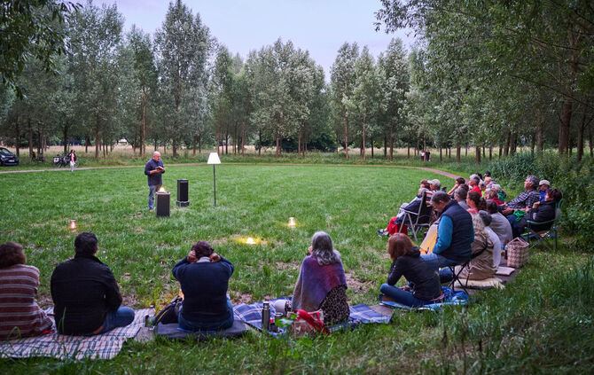 Besucher lauschen einer Lesung in der Kunstlichtung in der Talaue Waiblingen.
