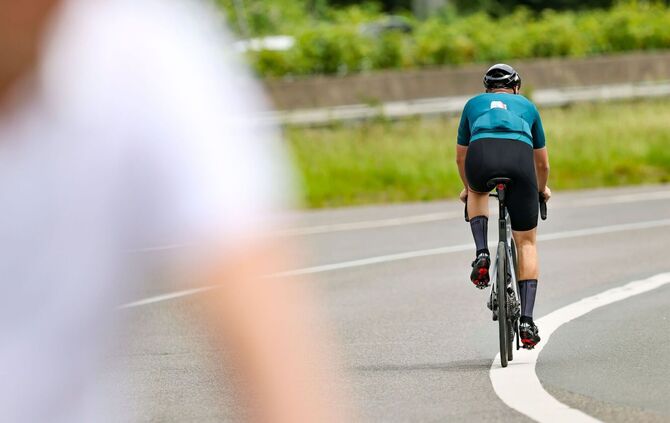 Ein Radfahrer fährt in der Sonne auf seinem Rennrad