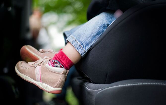 Mädchen sitzt in einem Kindersitz im Auto
