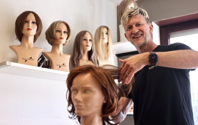 Friseurmeister Kai Schäftlmeier bei der Arbeit an einer Perücke.
