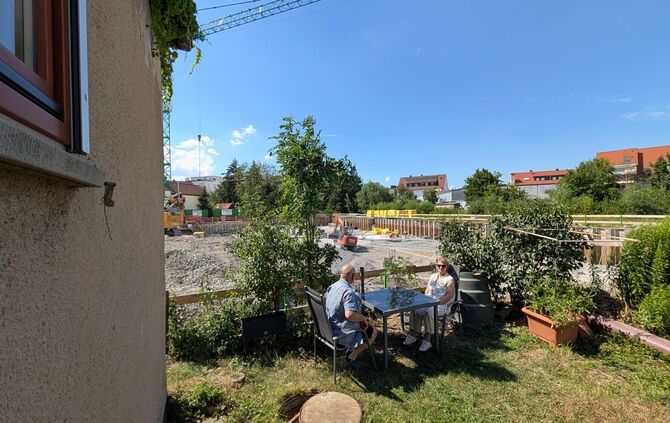 Franz und Edeltraud Schuster in ihrem Garten - mit bestem Blick auf die Baustelle für das "Altstadtquartier".