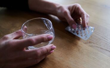 Frau hält Tabletten in der Hand